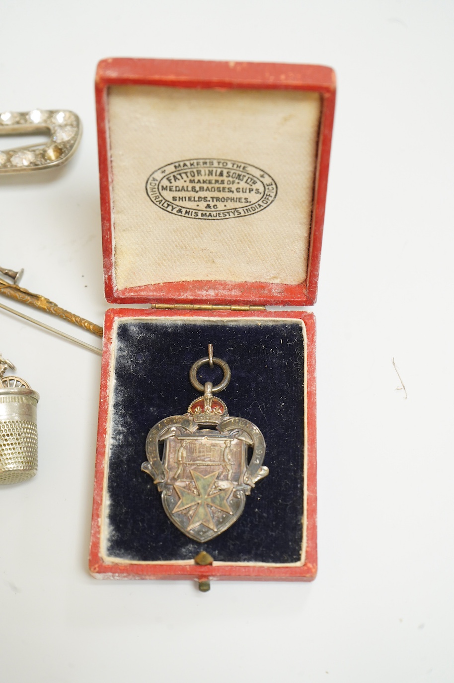 A small collection of silver and white metal charms, including Holy Bible, Penny Farthing, hedgehog and squirrel, together with a silver compact and ashtray, a silver and paste brooch, nut vesta, pipe, etc.